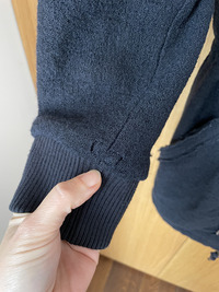 image de manteau adulte en laine avec trou d'usure sur le poignet de manche